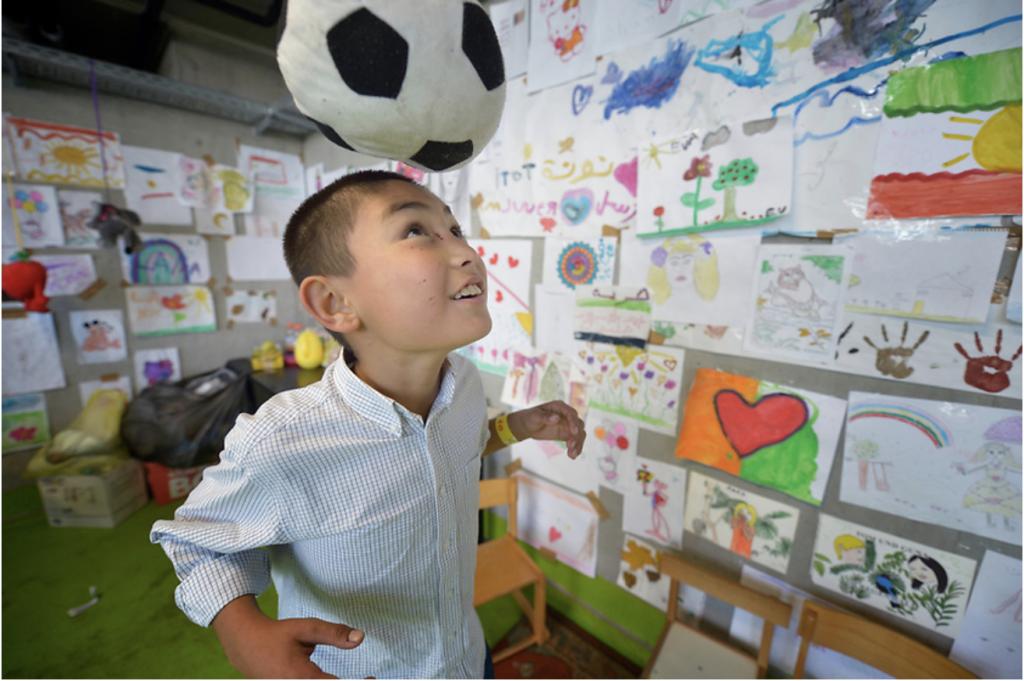 Young boy of Indonesia descent practicing his football skills in a class 